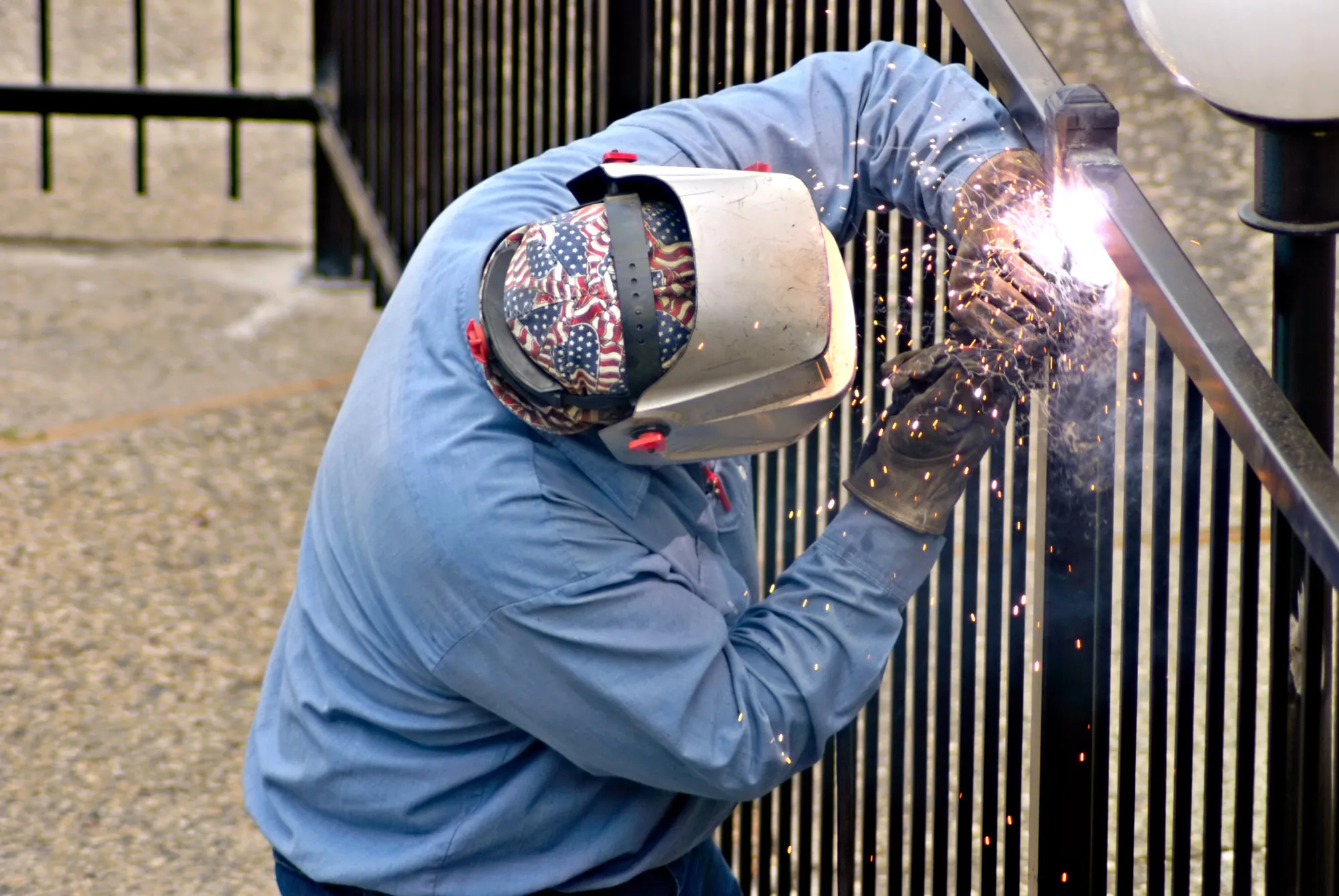 Patriot welder working on an ornamental iron railing